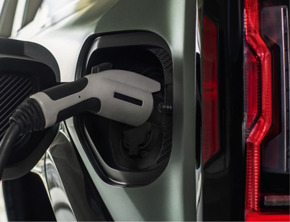 Close up of charging port with charger plugged in on a GMC Hummer EV SUV - Bruner Stephenville GMC in Stephenville TX
